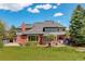 Beautiful two-story brick home features a stone patio, a spacious yard, and mature landscaping at 9141 Roundtree Dr, Highlands Ranch, CO 80126
