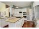 Spacious kitchen featuring an island with gas cooktop, double ovens, white cabinets, and granite countertops at 9141 Roundtree Dr, Highlands Ranch, CO 80126