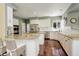 Bright kitchen featuring white cabinetry, granite countertops, stainless steel appliances, and hardwood floors at 9141 Roundtree Dr, Highlands Ranch, CO 80126