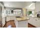 Open kitchen with an island and cooktop, white cabinets, stainless steel appliances, and ample counter space at 9141 Roundtree Dr, Highlands Ranch, CO 80126
