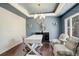 Stylish office with modern light fixture, designer chairs, and a sleek white desk at 9141 Roundtree Dr, Highlands Ranch, CO 80126