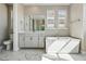 This primary bathroom has a soaking tub, marble floors and natural light from the windows at 9329 Russell Cir, Arvada, CO 80007