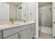 Modern bathroom featuring double sinks, a large mirror, and shower/tub combo at 9329 Russell Cir, Arvada, CO 80007