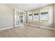 A modern bedroom with wood floors, neutral walls and double doors to outside at 9329 Russell Cir, Arvada, CO 80007