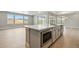 Kitchen island with sink and stainless appliances, with views through a large window at 9329 Russell Cir, Arvada, CO 80007
