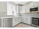 A modern kitchen featuring white cabinets, stainless steel appliances and grey tile backsplash at 9329 Russell Cir, Arvada, CO 80007
