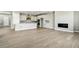 Bright, open-concept living space with hardwood floors, a modern fireplace, and an adjacent kitchen at 9329 Russell Cir, Arvada, CO 80007