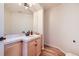 Powder room with wood vanity, white sink and framed mirror at 6598 S Telluride St, Aurora, CO 80016