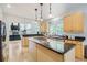 Eat-in kitchen featuring an island, granite counters, wood cabinets, hardwood floors and stainless appliances at 6598 S Telluride St, Aurora, CO 80016