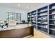 Well-lit home office with a large desk, built-in shelving, and serene window views at 6598 S Telluride St, Aurora, CO 80016