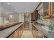 Long basement bar with granite countertop, wine fridge, and ample storage at 5320 S Race Ct, Greenwood Village, CO 80121