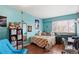 Bright bedroom with an organized bookshelf, mirror and window at 5512 S Greenwood St, Littleton, CO 80120