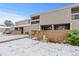 Tan townhouse featuring brick facade, small porch and balcony in a snowy outdoor setting on a sunny day at 5512 S Greenwood St, Littleton, CO 80120