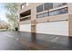 View of the townhouse garages with white doors on an asphalt driveway; townhouses have balconies at 5512 S Greenwood St, Littleton, CO 80120