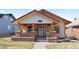 Charming bungalow featuring a welcoming front porch with brick accents and a well-maintained lawn at 3225 S Sherman St, Englewood, CO 80113