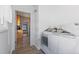 Bright laundry room featuring wood floors, wainscoting, and access to the kitchen at 3225 S Sherman St, Englewood, CO 80113