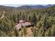 A home blends into a dense forest with mountain views at 9107 S Deer Creek Canyon Rd, Littleton, CO 80127