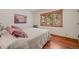 Cozy bedroom featuring hardwood floors, natural light, and comfortable bedding at 9107 S Deer Creek Canyon Rd, Littleton, CO 80127