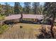 Expansive single story home featuring a wall of windows nestled among mature trees on a sunny lot at 9107 S Deer Creek Canyon Rd, Littleton, CO 80127