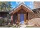 Inviting front entrance with a striking blue door and a stone facade at 9107 S Deer Creek Canyon Rd, Littleton, CO 80127