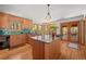 Bright kitchen featuring a large island, wood cabinets, and access to an outdoor seating area at 9107 S Deer Creek Canyon Rd, Littleton, CO 80127