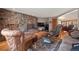 Welcoming living room featuring a stone fireplace, hardwood floors and traditional decor at 9107 S Deer Creek Canyon Rd, Littleton, CO 80127