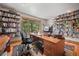 Spacious home office with a built-in desk and ample shelving for storage and organization at 9107 S Deer Creek Canyon Rd, Littleton, CO 80127