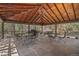 Covered outdoor patio with seating and dining table with view of the surrounding trees at 9107 S Deer Creek Canyon Rd, Littleton, CO 80127