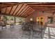 Covered outdoor patio with seating and dining table with view of the surrounding trees at 9107 S Deer Creek Canyon Rd, Littleton, CO 80127
