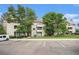 Attractive condo building featuring a lawn, mature trees, balconies and convenient parking at 7468 S Alkire St # 205, Littleton, CO 80127