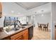 Modern kitchen overlooking living space, with stainless sink and adjacent dining area at 7468 S Alkire St # 205, Littleton, CO 80127