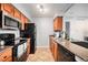 Galley kitchen featuring stainless microwave, black appliances and stone countertops at 7468 S Alkire St # 205, Littleton, CO 80127