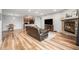Open-concept living room features hardwood floors, stone fireplace and flows into kitchen at 7468 S Alkire St # 205, Littleton, CO 80127