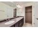 Bright bathroom with double sink vanity, granite countertops, large mirror, and shower for a spa-like experience at 5495 Espana Ct, Denver, CO 80249