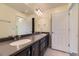 Bathroom featuring double sinks, dark cabinets, and lots of storage at 5495 Espana Ct, Denver, CO 80249