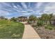 A landscaped community park offers a shaded picnic area and walking path on a beautiful day at 5495 Espana Ct, Denver, CO 80249
