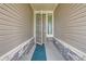 Close-up of the front door with a storm door and sidelight at 5495 Espana Ct, Denver, CO 80249