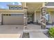 Inviting covered front porch with stone pillar accents and seating area at 5495 Espana Ct, Denver, CO 80249