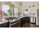 Bright kitchen with stone tile backsplash, stainless steel appliances, hardwood floors, and a view of the yard at 5495 Espana Ct, Denver, CO 80249