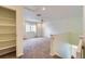 Inviting loft with soft carpeting, ceiling fan, bright window, and convenient closet for flexible living space at 5495 Espana Ct, Denver, CO 80249
