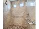 Modern shower room with pebble floor, glass doors and tiled walls at 5495 Espana Ct, Denver, CO 80249