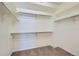 Spacious walk-in closet featuring ample shelving, metal rods, and neutral carpeting for optimal organization and storage at 5495 Espana Ct, Denver, CO 80249