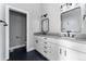 Modern bathroom with double vanity, sleek black fixtures, and tiled floors at 1524 Ingalls St, Lakewood, CO 80214