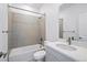 Modern bathroom featuring tiled shower and showerhead, white sink, and quartz countertop at 9382 Quaker St, Arvada, CO 80007
