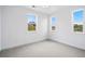 Bright bedroom featuring plush gray carpet, three bright windows, and neutral walls at 9382 Quaker St, Arvada, CO 80007