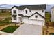 Charming two-story home with a modern design, white siding, dark trim and a spacious three car garage and concrete driveway at 9382 Quaker St, Arvada, CO 80007