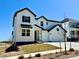 Beautiful two-story home featuring white siding, black accents, a manicured front lawn, and a two car garage at 9382 Quaker St, Arvada, CO 80007