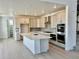 Bright kitchen with stainless steel appliances, a large island with a sink, and light hardwood flooring at 9382 Quaker St, Arvada, CO 80007