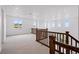 Spacious upper loft with wood railing and neutral carpet, offering flexible living space at 9382 Quaker St, Arvada, CO 80007