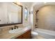 Bathroom featuring neutral tile, built-in shower niche, large framed mirror, and window for light and views at 4002 Bell Mountain Dr, Castle Rock, CO 80104